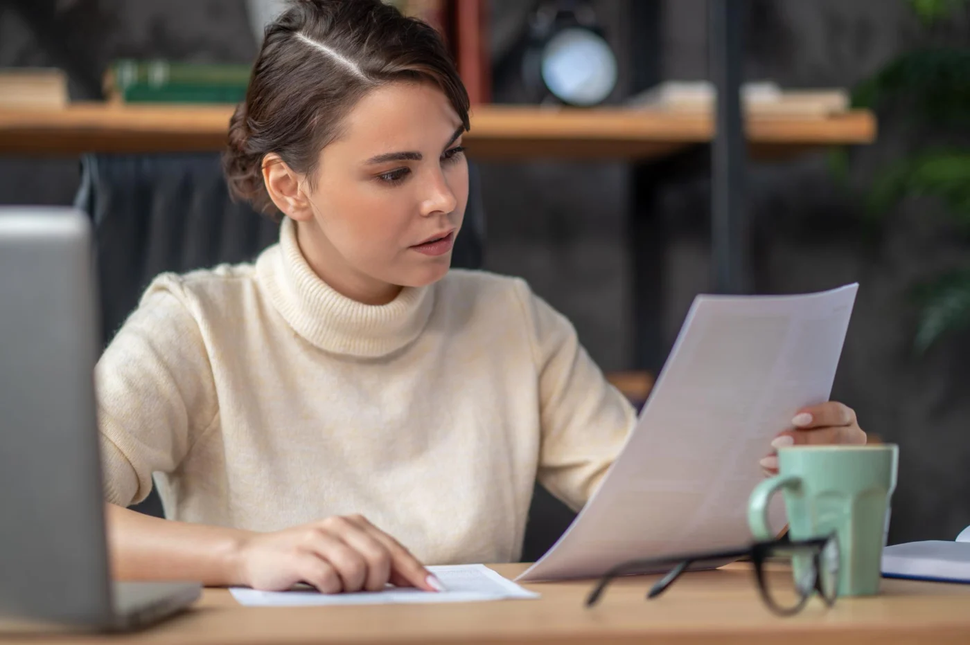 An independent contractor reading through a document at their desk
