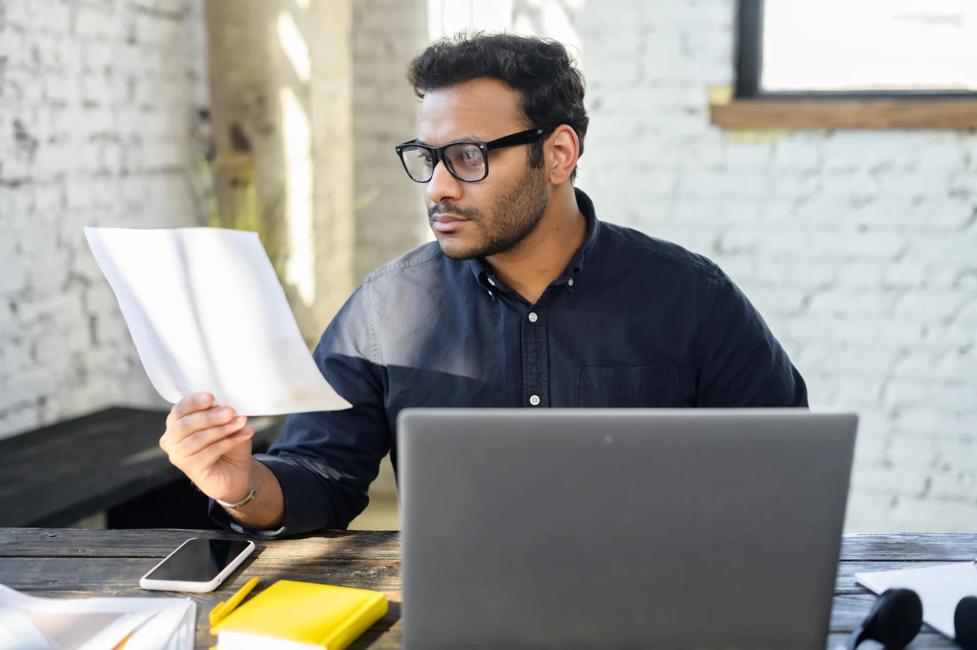 An independent professional reviewing a business-to-business contract for services at a desk
