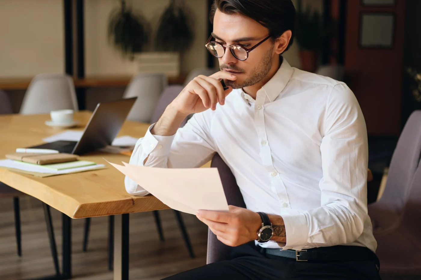A self-employed professional reading through paperwork before filing it