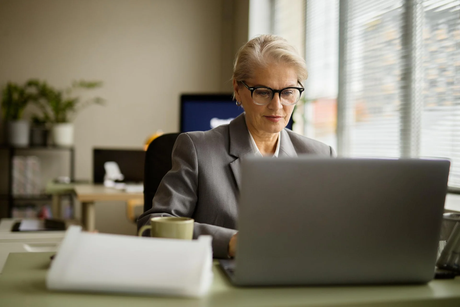 An independent professional working at a laptop in a modern office
